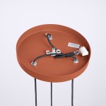 Lampa wisząca Halo w kolorze ochra czerwona, z okrągłym, matowym uchwytem. Widoczne trzy przewody z końcówkami oraz miejsce na trzy żarówki G9. Tło białe, produkt widoczny z góry.