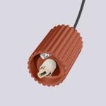 Lampa wisząca Halo w kolorze ochra czerwona, z gładką, teksturowaną obudową w kształcie cylindra. Widoczny gwint G9 do żarówki oraz czarny kabel zawieszenia. Ujęcie z góry, pokazujące detal mocowania.