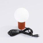 Lampa stołowa Halo 1xG9 w kolorze ochra czerwona, z okrągłym, białym kloszem i teksturowanym, cylindrycznym słupkiem. Widoczny czarny przewód z włącznikiem. Ujęcie frontalne na białym tle.