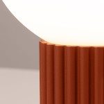 Lampa stołowa Halo z czerwonym, teksturowanym stojakiem w formie żeber i okrągłą, białą kloszem. Ujęcie z bliska, ukazujące detal podstawy. Idealna do nowoczesnych aranżacji wnętrz.