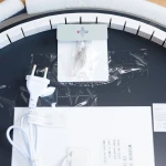 Lustro podświetlane D60 z oświetleniem LED 24W w kształcie koła, transparentne. Widoczny kabel z wtyczką oraz akcesoria montażowe. Lustro ma czarną tylną płytę z etykietami. Ułożone na płaskiej powierzchni, otoczone styropianowymi zabezpieczeniami.