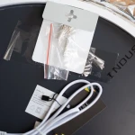 Lustro podświetlane D60 w kształcie koła, z elementami LED 24W CCT. Widoczne akcesoria montażowe, przewody oraz etykieta z danymi technicznymi. Tło ciemne, lustro leży płasko.