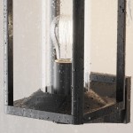 Kinkiet elewacyjny Cell w kolorze grafitowym, z miejscem na żarówkę E27, z przezroczystym kloszem, widoczny w zbliżeniu, z kroplami wody na powierzchni, o prostokątnym kształcie i minimalistycznym designie.