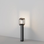 Lampa ogrodowa stojąca Cell H75 w kolorze grafitowym, z oprawą w kształcie sześcianu. Wyposażona w jedną żarówkę E27, umieszczona na prostym, kwadratowym słupku. Zdjęcie ukazuje lampę na szarym tle, oświetloną od wewnątrz.