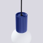 Lampa wisząca Halo w kolorze niebieskim z podłużnym, żebrowanym uchwytem oraz białą, okrągłą kloszem. Wisi na czarnym przewodzie. Widać szczegóły uchwytu i klosza w zbliżeniu, na jednolitym tle.