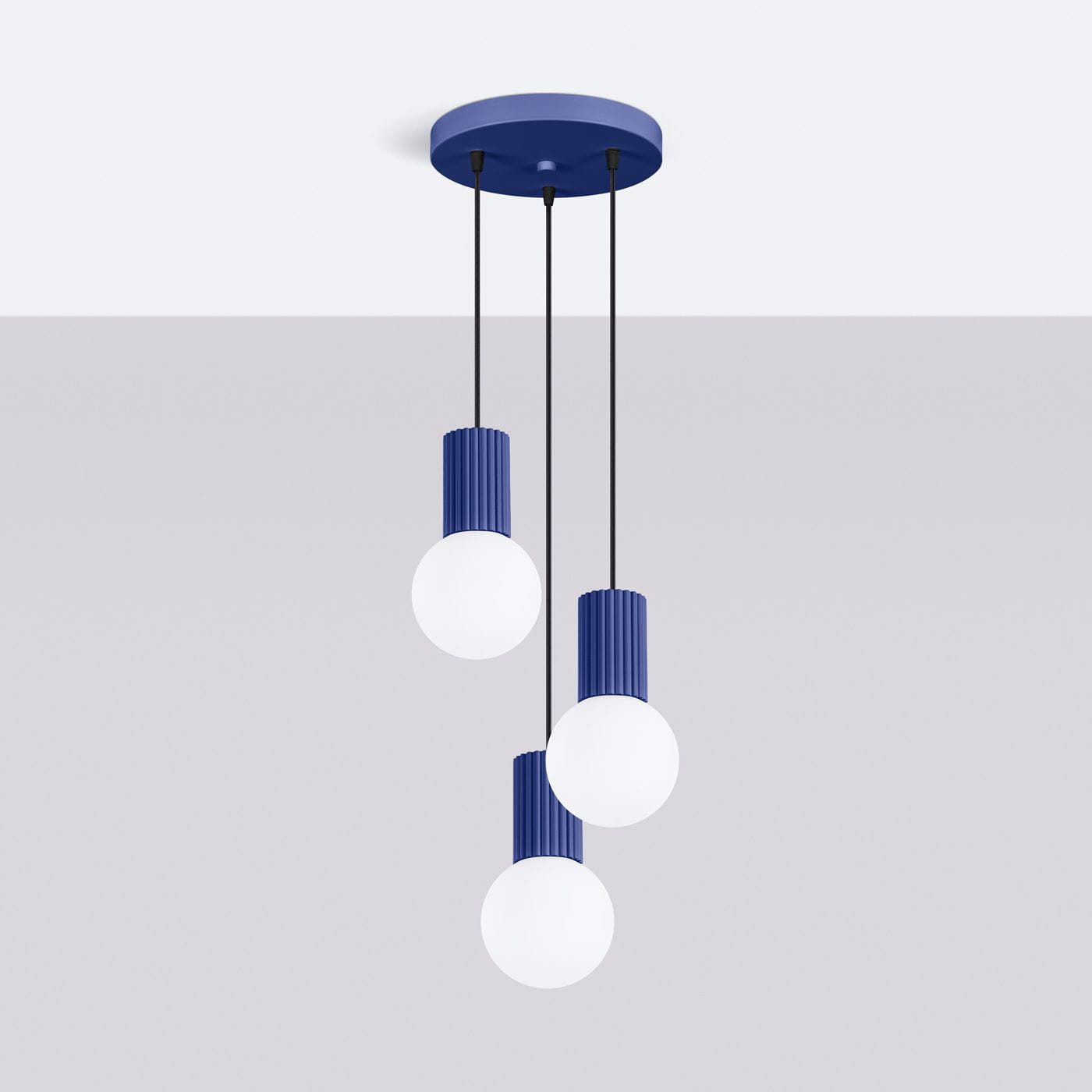 Lampa wisząca Halo 3xG9 w kolorze niebieskim z trzema szklanymi kulami, zawieszona na czarnych linkach. Klasyczna, okrągła podsufitka w tym samym odcieniu niebieskiego. Wzór na górnych częściach lampy w formie żłobienia.
