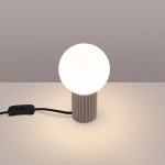 Lampa stołowa Halo w kolorze taupe z cylindrycznym, żłobionym podstawą i okrągłą, białą kulą. Widoczne przewody z włącznikiem w kolorze czarnym. Produkt umieszczony na jasnym tle.
