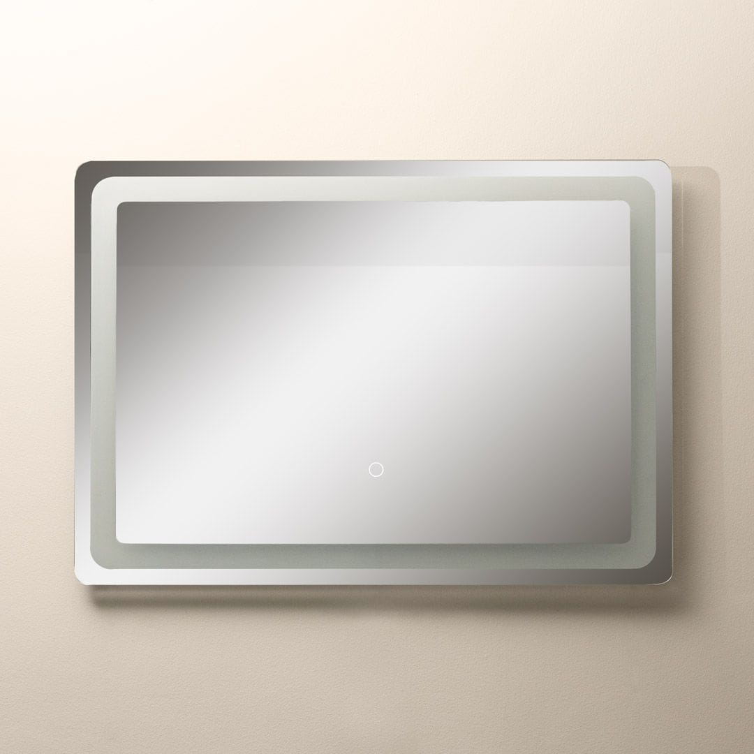 Lustro podświetlane LED 70x50 cm w prostokątnym kształcie, z białą ramą. Widoczny przycisk dotykowy na dolnej części. Lustro montowane na ścianie, na jasnym tle, z równomiernym rozproszeniem światła.