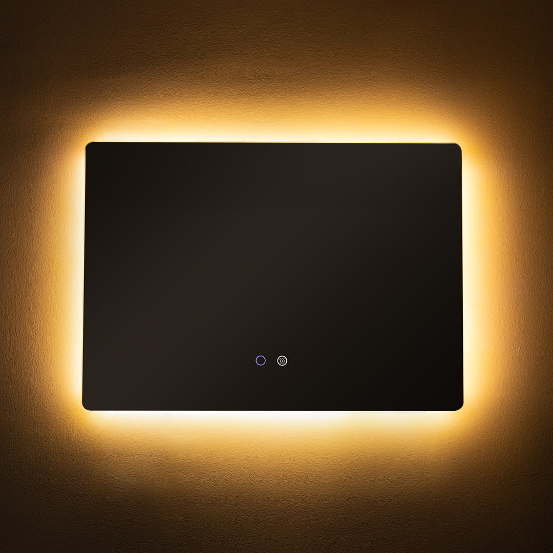 Lustro podświetlane 70x50 cm, prostokątne, bezramkowe, z podświetleniem LED 24W CCT. Ujęcie frontalne, włączniki dotykowe w dolnej części. Otoczenie w ciepłym, stonowanym odcieniu ściany.