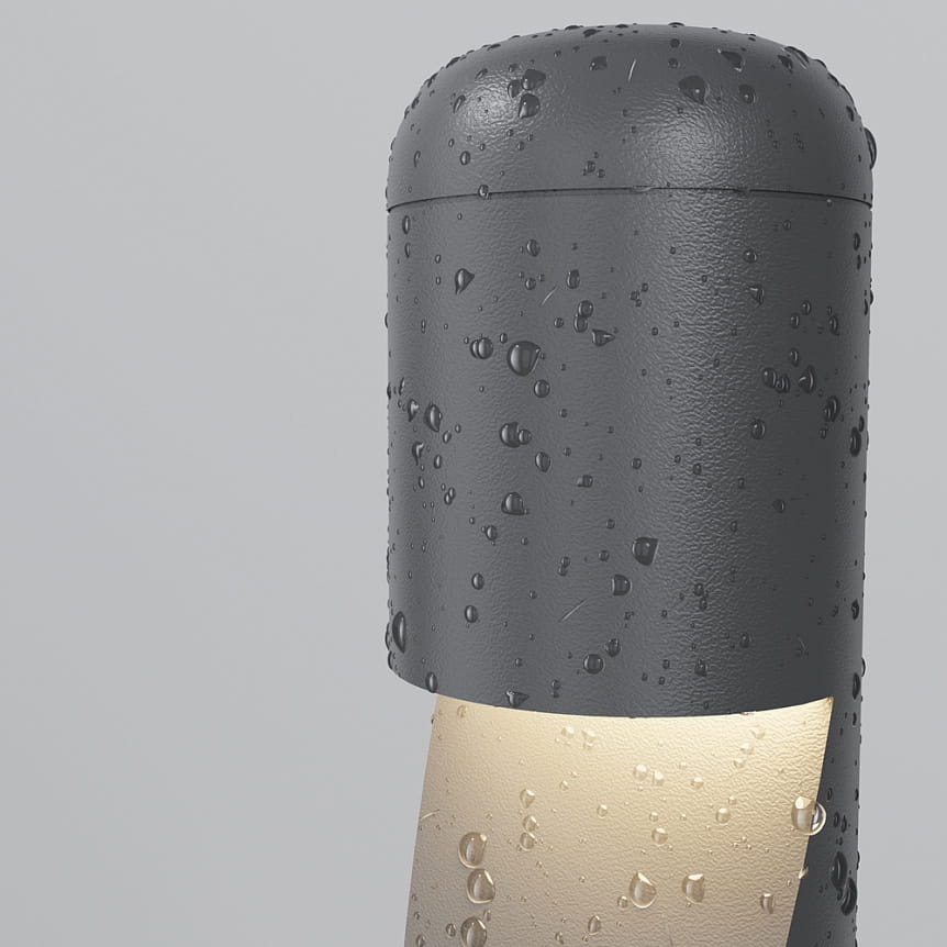 Grafitowa lampa ogrodowa LED Hagen H60 o mocy 5W i temperaturze barwowej 3000K, z widocznymi kroplami wody na powierzchni, w kształcie cylindrycznym. Emituje ciepłe światło z dolnej części, ustawiona prosto.
