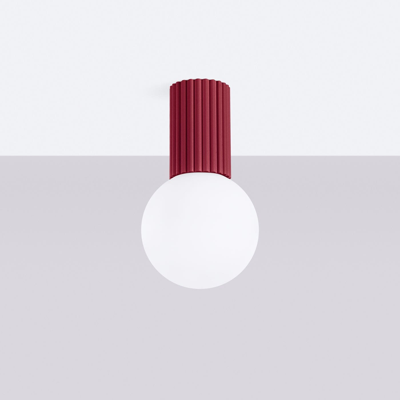 Lampa sufitowa Halo z burgundowym, żebrowanym kloszem i okrągłą, białą żarówką. Zawieszona na suficie, w prostym, jasnym tle. Idealna do nowoczesnych wnętrz. Wodoodporność IP44.