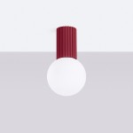 Lampa sufitowa Halo z burgundowym, żebrowanym kloszem i okrągłą, białą żarówką. Zawieszona na suficie, w prostym, jasnym tle. Idealna do nowoczesnych wnętrz. Wodoodporność IP44.