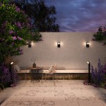 Lampa ogrodowa LED Stock H80 7W 3000K w kolorze grafitowym, umieszczona w otoczeniu roślinności, oświetlająca strefę wypoczynkową z drewnianym stołem i metalowymi krzesłami. Widoczna na tle betonu i zieleni, z nowoczesnym designem.