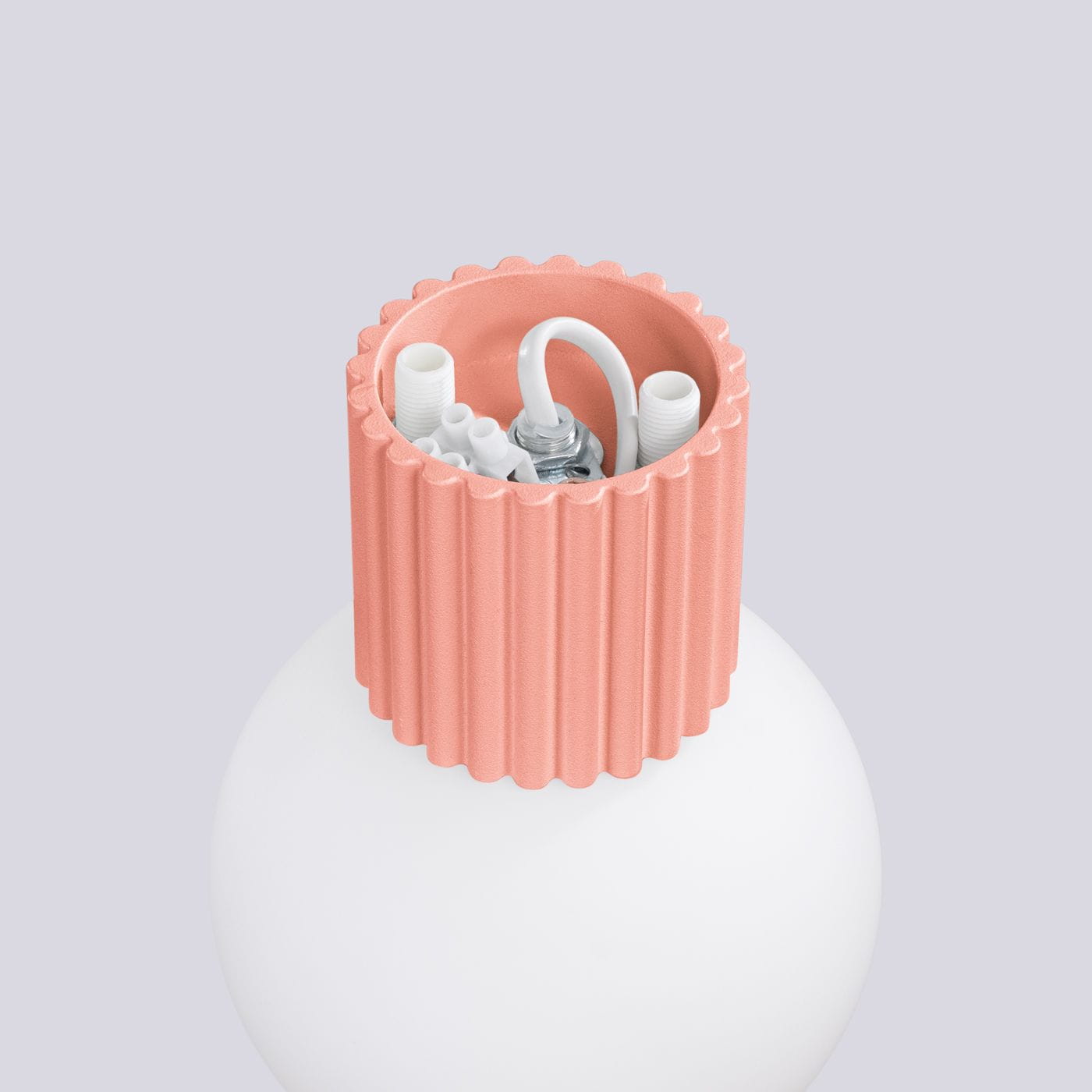 Kinkiet Halo 1xG9 IP44 w kolorze brzoskwiniowym, z widocznym gwintem i białymi przewodami. Ujęcie z góry, pokazujące fakturowaną obudowę i miejsce na żarówkę, na tle jasnoszarym.