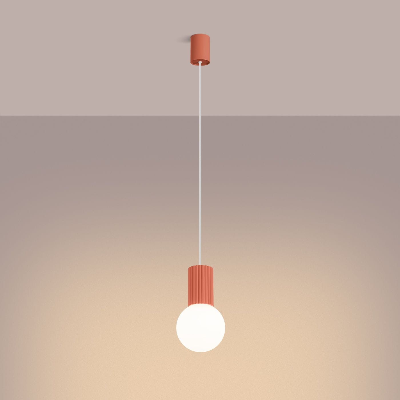 Brzoskwiniowa lampa wisząca Halo z oprawą na żarówkę G9. Wisi na cienkim przewodzie, z cylindrycznym mocowaniem u góry. Kula szklana u dołu emituje miękkie światło, a teksturowana oprawa dodaje nowoczesnego charakteru.