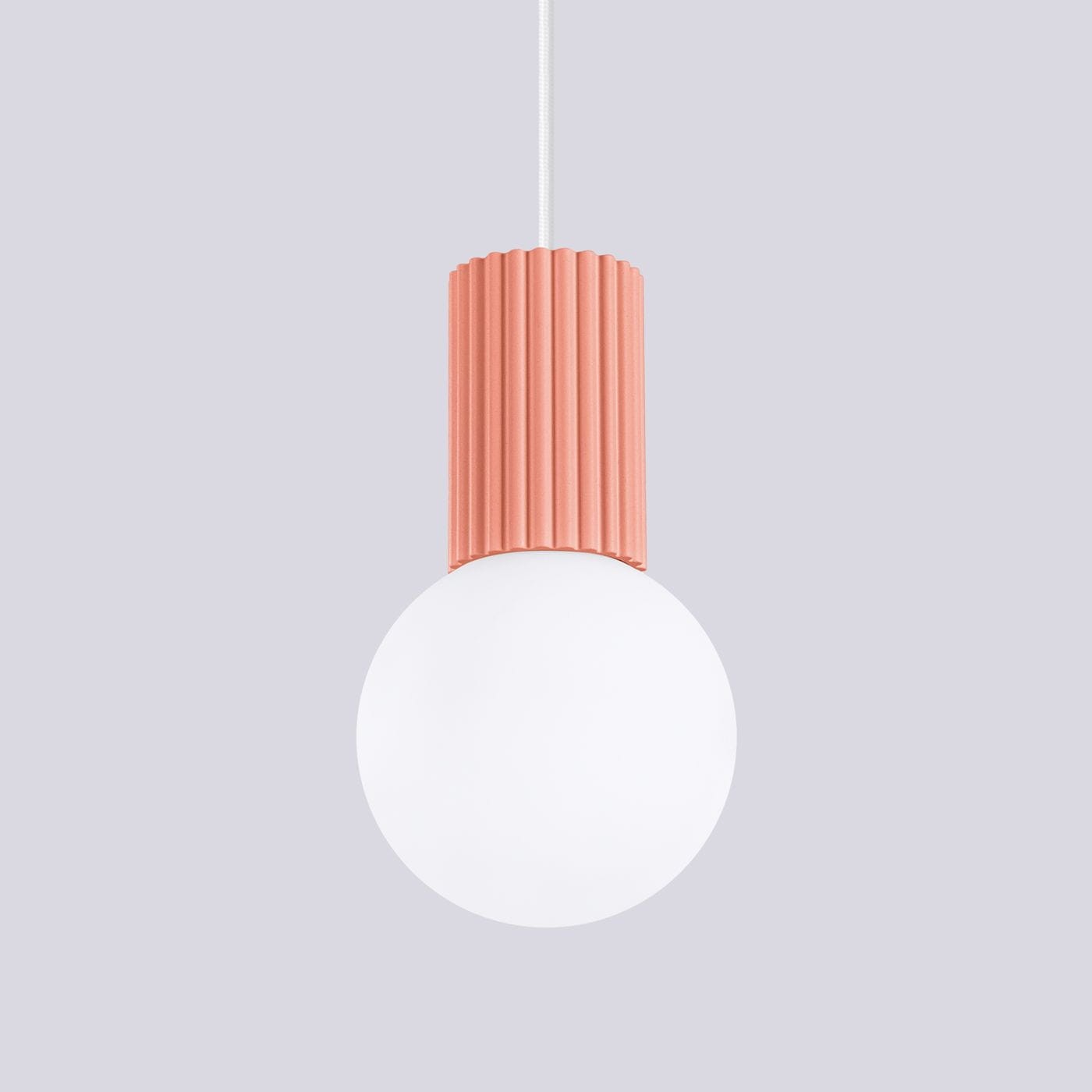 Lampa wisząca Halo z brzoskwiniowym, żebrowanym kloszem i białą, okrągłą żarówką, zawieszona na białym przewodzie. Prosta forma, idealna do nowoczesnych wnętrz. Tło w jasnoszarym kolorze.