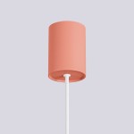 Lampa wisząca Halo w kolorze brzoskwiniowym z cylindrycznym kloszem, zawieszona na białym, plecionym przewodzie. Ujęcie z dołu, pokazujące detale klosza i sposób mocowania.