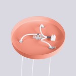 Brzoskwiniowa lampa wisząca Halo z trzema gniazdami G9. Widok z góry, ukazujący okrągły, matowy klosz oraz przewody elektryczne złącza. Produkt zamontowany na płaskiej powierzchni, z wyraźnymi detalami mocowania i przewodów.