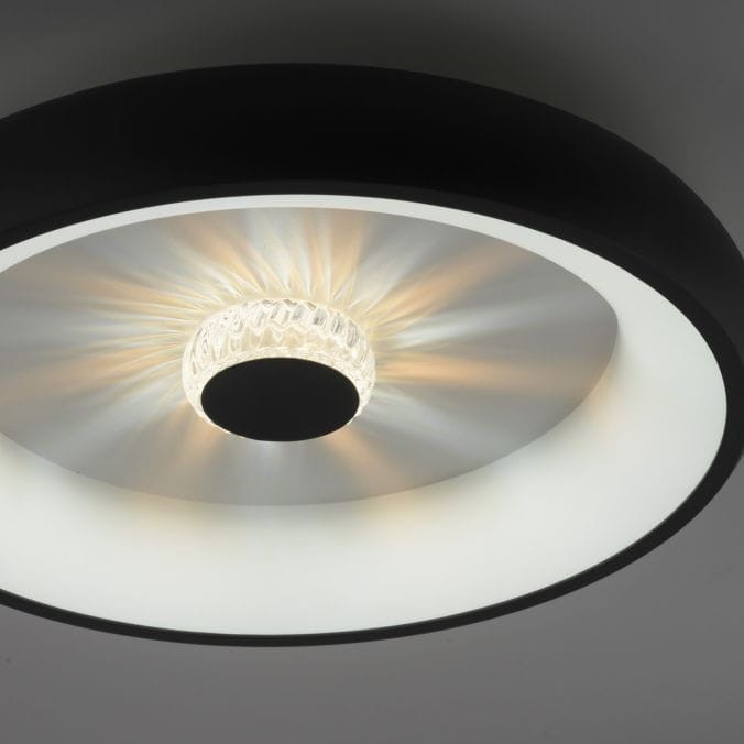 Plafon LED Vertigo 29W CCT w kolorze czarnym, z okrągłym metalowym body i przezroczystym elementem świetlnym w centrum. Ujęcie z góry, ukazujące delikatne światło rozpraszające się z wnętrza. Produkt zdalnie sterowany pilotem.
