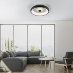 Plafon LED Vertigo 29W CCT w kolorze czarnym, okrągły, zamontowany na suficie. Wyposażony w pilot do zdalnego sterowania. Tło przedstawia nowoczesny salon z dużymi oknami i meblami w odcieniach szarości.