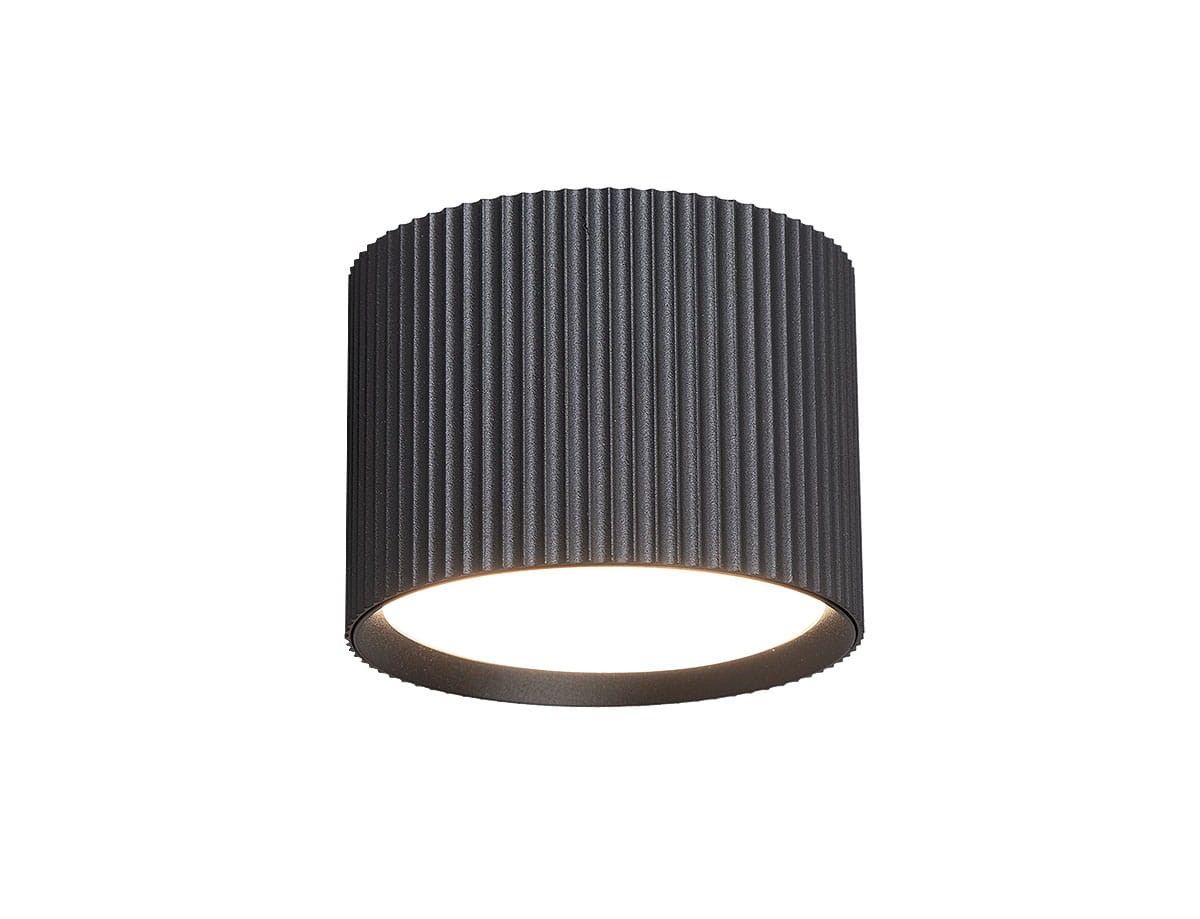Czarna lampa sufitowa tuba GX53 z wypukłą, żebrowaną powierzchnią. Ujęcie frontalne, lampa w pozycji wiszącej, emitująca ciepłe światło z dolnej krawędzi. Brak widocznych napisów lub logo.