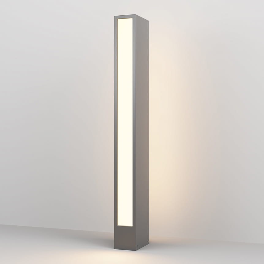 Grafitowa lampa ogrodowa LED Hof H60 o mocy 12W i barwie światła 3000K. Posiada prostokątną, smukłą konstrukcję z wbudowanym panelem świetlnym, emitującym ciepłe światło, stojąca na stabilnej podstawie.