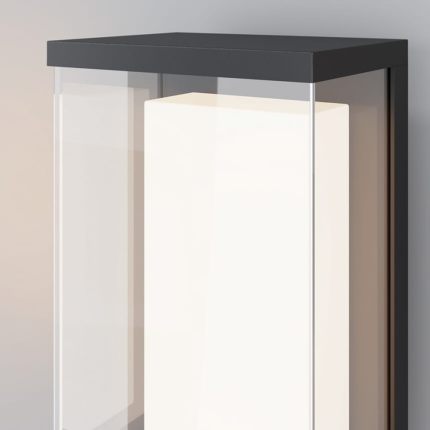 Kinkiet elewacyjny LED Baker Street 10W 3000K w kolorze czarnym. Produkt ma prostokątną, minimalistyczną obudowę z przezroczystymi ściankami, ukazującymi białe źródło światła. Ujęcie z przodu, pod kątem, eksponuje jego nowoczesny design.