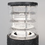 Lampa ogrodowa Bronx H25 w kolorze czarnym, z oprawą na jedną żarówkę E27. Transparentny klosz z wodoodporną powłoką, widoczne elementy wewnętrzne i mocowanie. Ujęcie z bliska, podkreślające detale konstrukcji.