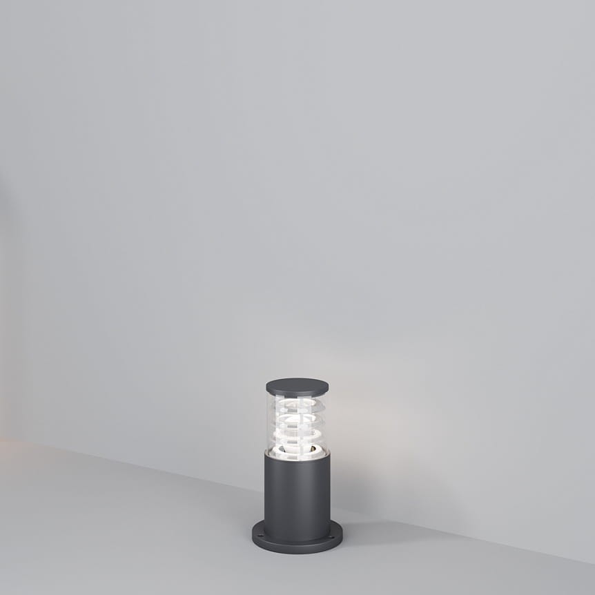 Lampa ogrodowa Bronx H25 w kolorze grafitowym, z oprawą na żarówkę E27. Ma cylindryczny kształt z przezroczystym kloszem, ukazującym spiralny element wewnętrzny. Ustawiona na płaskiej powierzchni, na jednolitym tle.