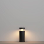 Lampa ogrodowa Olten H30 LED 12W 3000K w kolorze grafitowym. Stojąca, cylindryczna konstrukcja z okrągłym kloszem u góry, emitująca ciepłe światło. Tło proste, jednolite, co podkreśla minimalistyczny design lampy.