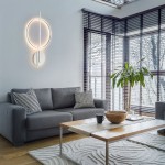 Lampa sufitowa Q-arkoa z pilotem, srebrna, z dwoma źródłami LED 36W CCT. Zawieszona na ścianie, w nowoczesnym wnętrzu z szaro-beżową sofą, drewnianym stołem i rośliną. Oświetlenie w kształcie okręgu, z metalowym detalem.
