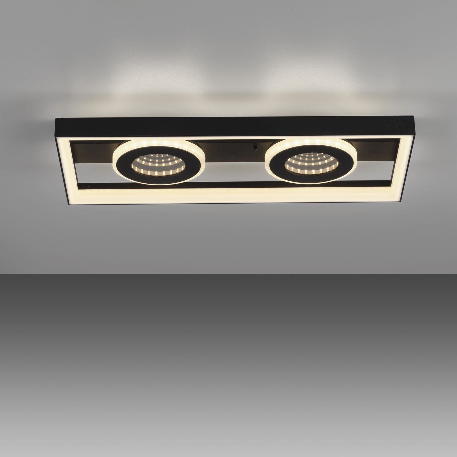 Traforo lampa sufitowa LED 20W CCT w kolorze czarnym, prostokątna. Posiada dwa okrągłe źródła światła z pierścieniowym podświetleniem. Ujęcie z góry, montowana na suficie, idealna do nowoczesnych wnętrz.