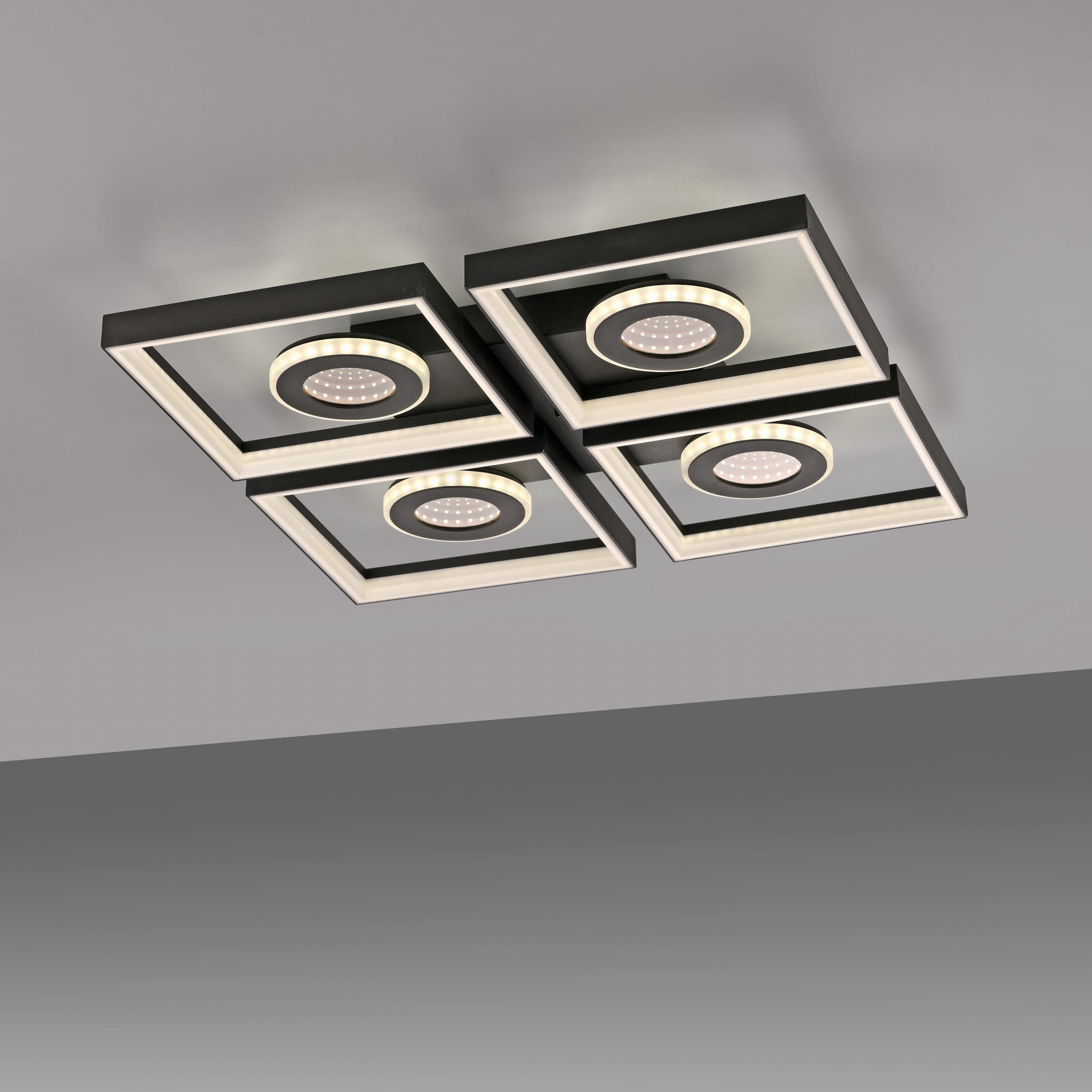 Lampa sufitowa Traforo LED 35W CCT w kolorze czarnym, składająca się z czterech kwadratowych paneli z okrągłymi źródłami światła. Ujęcie z dołu, ukazujące nowoczesny design i detale wykończenia. Wbudowany pilot do zdalnego sterowania.