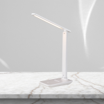 Lampa biurkowa LED 5W CCT w kolorze białym, z regulowanym ramieniem. Ujęcie z boku, stojąca na marmurowym blacie. Prosta forma z podświetlaną górną częścią. Tło w jednolitym odcieniu szarości, co podkreśla elegancki design.