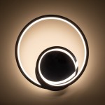 Kinkiet LED Lucero 13W 4000K w kolorze chromu, złożony z dwóch okrągłych elementów, jeden większy zewnętrzny i mniejszy wewnętrzny, emitujący ciepłe światło. Montowany na ścianie, z minimalistycznym designem, na jednolitym tle.