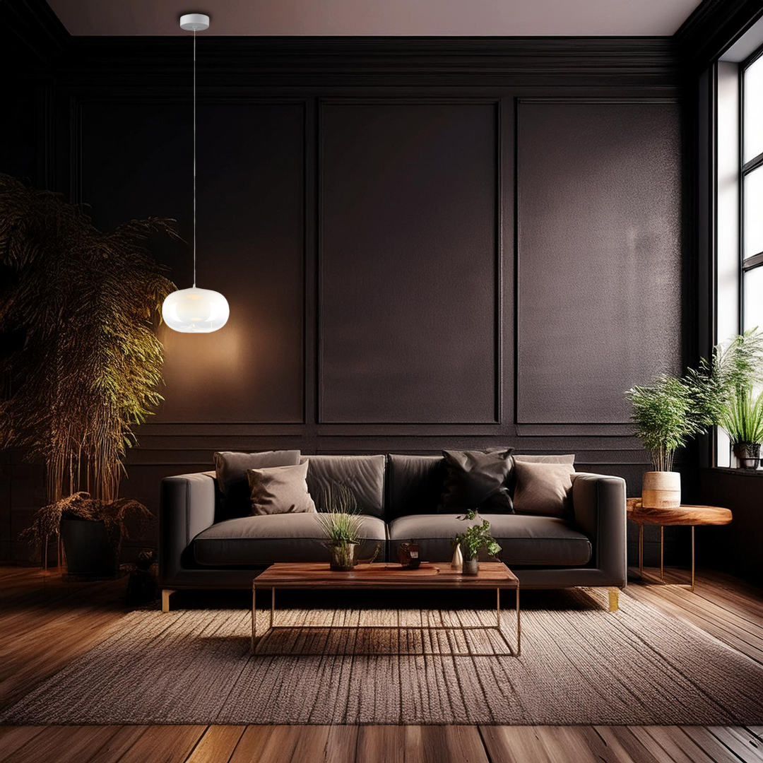 Lampa wisząca LED Vaso 1 l, 4W, 3000K w kolorze białym, zawieszona na cienkim przewodzie, umieszczona nad ciemnoszarym sofą w nowoczesnym wnętrzu. Tło to ciemne ściany, drewniana podłoga, rośliny i stół kawowy.