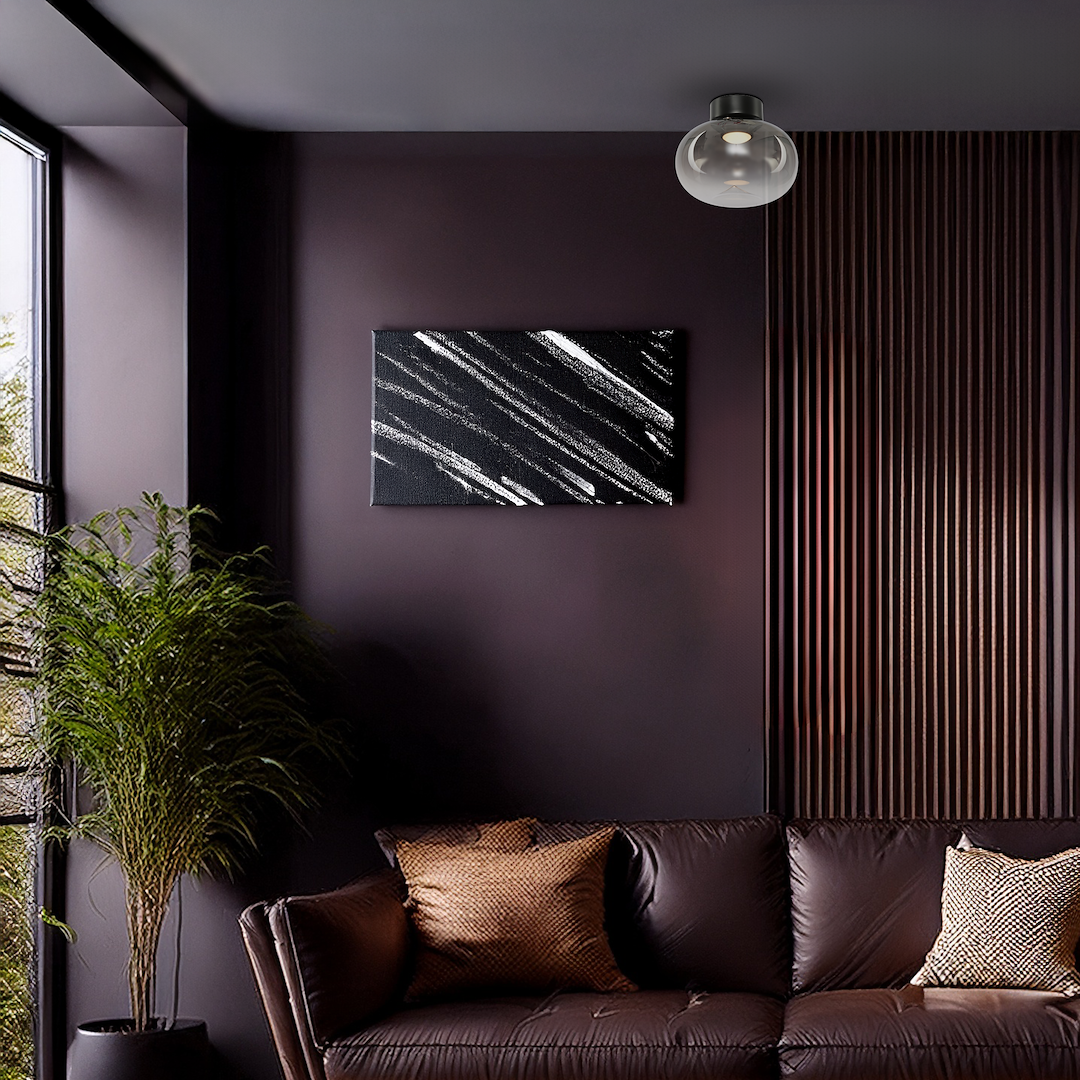 Lampa sufitowa LED Vaso 4W 3000K w kolorze czarnym z dymionym kloszem, zamontowana na suficie w nowoczesnym wnętrzu. W tle widoczne ciemne ściany, sofa z poduszkami oraz obraz o abstrakcyjnym wzorze.