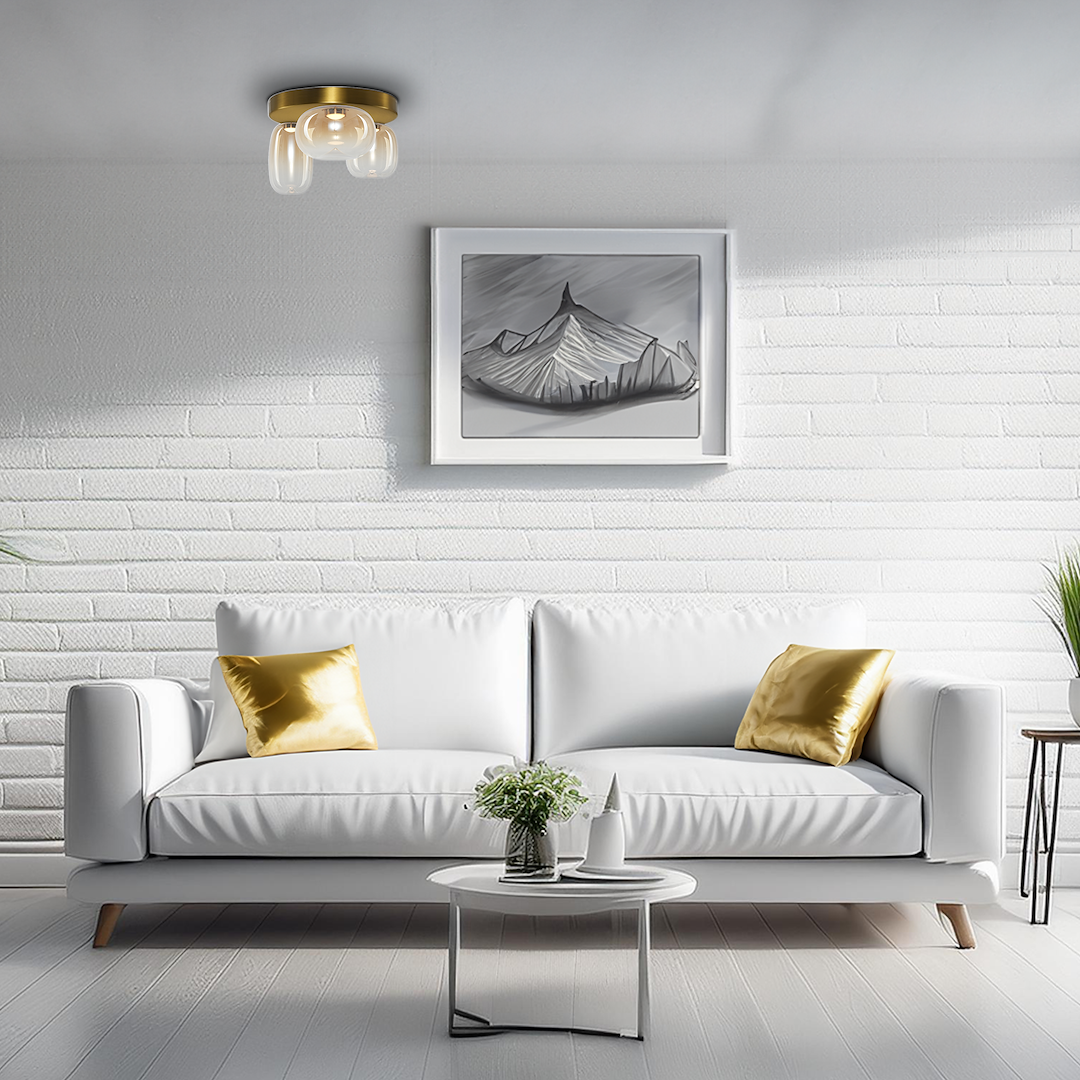 Lampa sufitowa LED Vaso 12W 3000K w kolorze złotym i bursztynowym, montowana na suficie. Posiada trzy szklane klosze o zaokrąglonym kształcie. W tle widoczny nowoczesny salon z białą kanapą i dekoracjami w odcieniach złota.