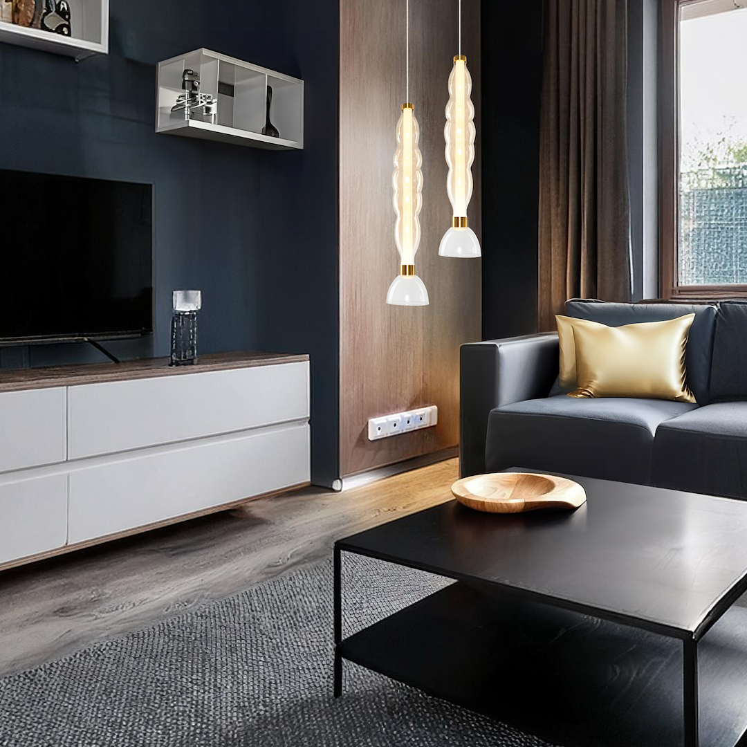 Lampa wisząca LED Lucco 18W w kolorze złotym i bursztynowym, z charakterystycznym, falistym kloszem i białą podstawą. Zawieszona w nowoczesnym wnętrzu, nad czarnym stołem, obok szarej kanapy z złotą poduszką.