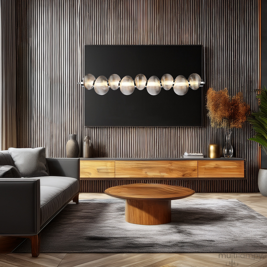 Lampa wisząca LED Bolla 32W 3000K w chromowanej obudowie z dymionymi kloszami, zawieszona nad niskim okrągłym stolikiem w nowoczesnym wnętrzu. Tło z naturalnym drewnem i dekoracjami, stonowane kolory.