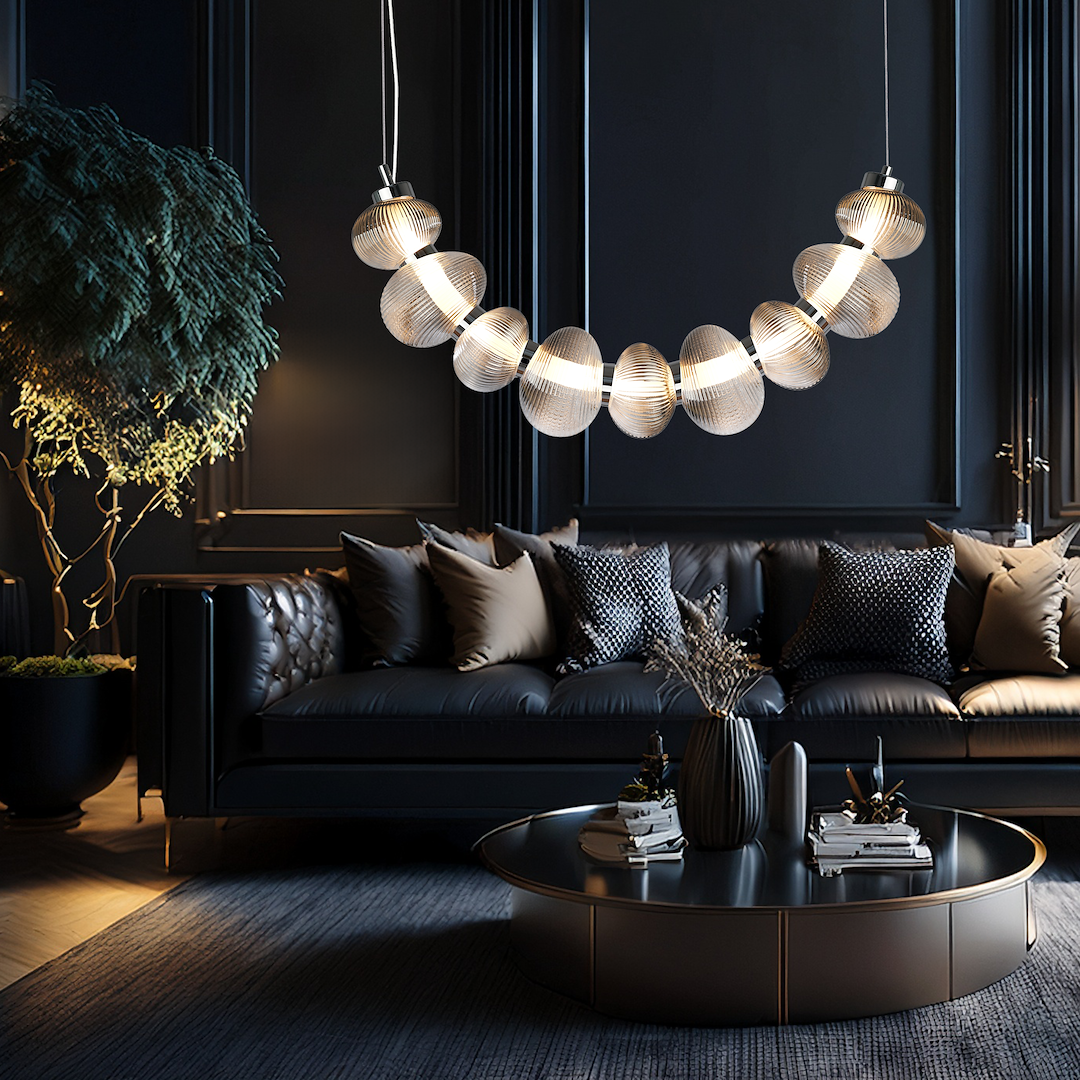 Lampa wisząca LED Bolla 36W 3000K w chromowanej oprawie z dymionymi kloszami, zawieszona nad czarną sofą. W tle ciemne ściany i eleganckie poduszki, z rośliną w donicy po lewej stronie.