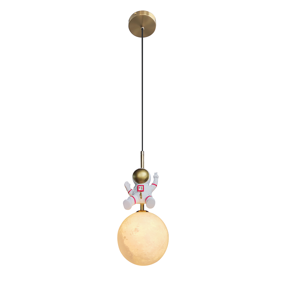 Lampa wisząca Astronauta z metalowym, złotym uchwytem i białą kulą imitującą Księżyc, z postacią astronauty w białym skafandrze trzymającą rękę w górze. Produkt zawieszony na czarnym przewodzie.