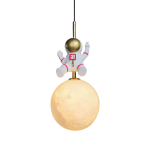 Lampa wisząca w kształcie astronauty z białym skafandrem i złotą hełmem, zawieszona nad okrągłą, jasną kulą przypominającą księżyc. Produkt ma czarny przewód i złoty uchwyt. Idealna jako oryginalna dekoracja do wnętrz.