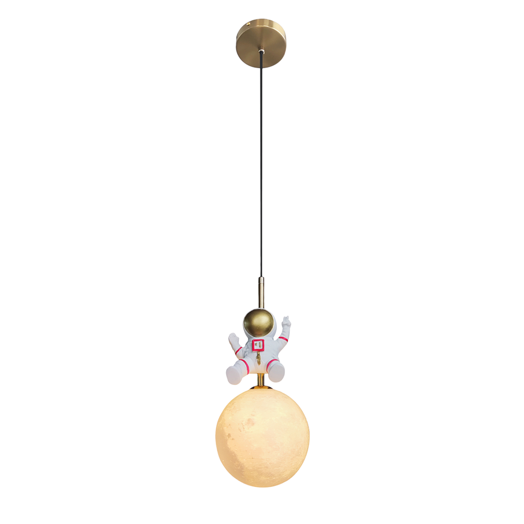Lampa wisząca Astronauta z żarówką E27, złota i biała. Zawieszona na czarnym kablu, z figurką astronauty w białym skafandrze, siedzącą na lampie w kształcie księżyca. Kształt okrągły, matowa powierzchnia lampy, prosta konstrukcja.