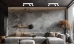 Lampa sufitowa Magnet 3xGU10 w białym kolorze, z trzema ruchomymi reflektorami LED 5W CCT. Zainstalowana na ciemnym suficie, w nowoczesnym wnętrzu z szarymi tonami i elementami drewnianymi.