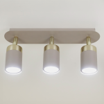 Lampa sufitowa Joker z trzema reflektorami GU10 w kolorze kaszmiru i złota. Ułożona poziomo z okrągłymi kloszami, emitującymi jasne światło. Montowana na płaskiej podstawie, idealna do nowoczesnych wnętrz.