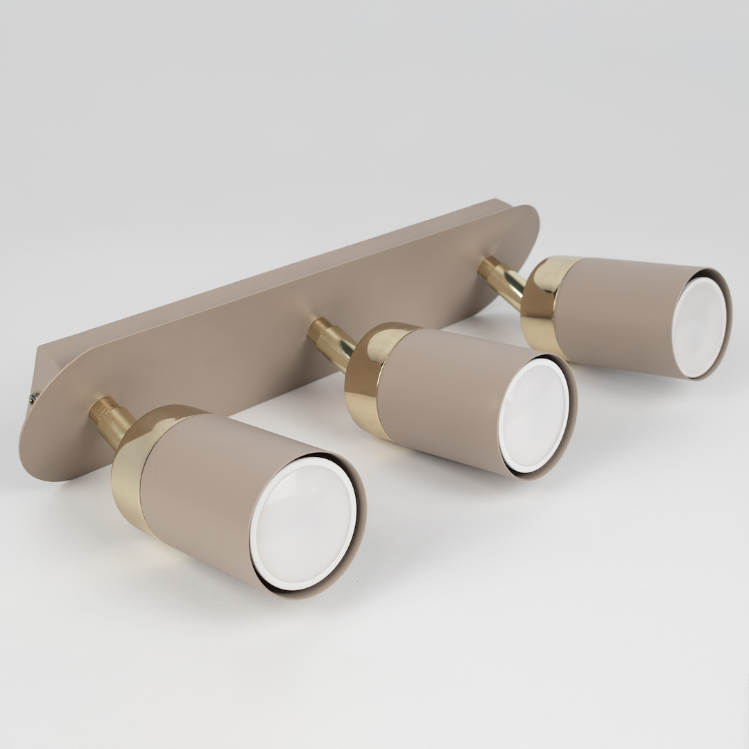 Lampa sufitowa Joker w kolorze kaszmiru z trzema punktami świetlnymi GU10, z metalowymi elementami w kolorze złotym. Ujęcie frontalne, pokazujące lampa zamontowaną na ścianie, z widocznymi detalami kloszy i mocowania.