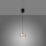 Lampa wisząca LED Rika 6W w kolorze czarnym, dymiony klosz w kształcie cylindrycznym, zawieszona na cienkim przewodzie, z metalowym mocowaniem sufitowym. Emituje ciepłe światło, idealna do nowoczesnych wnętrz.