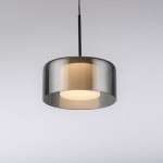 Lampa wisząca LED Rika 6W w kolorze czarnym dymionym, o okrągłym kształcie z półprzezroczystym kloszem. Zawieszona na cienkim czarnym przewodzie, z jasnym źródłem światła w środku. Tło jasne, proste.