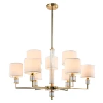 Złota lampa wisząca Sutton z dziewięcioma oprawami na żarówki E14. Posiada cylindryczne klosze w białym kolorze, metalową konstrukcję i szklane detale. Ujęcie frontalne, zawieszona na długim przewodzie, idealna do nowoczesnych wnętrz.